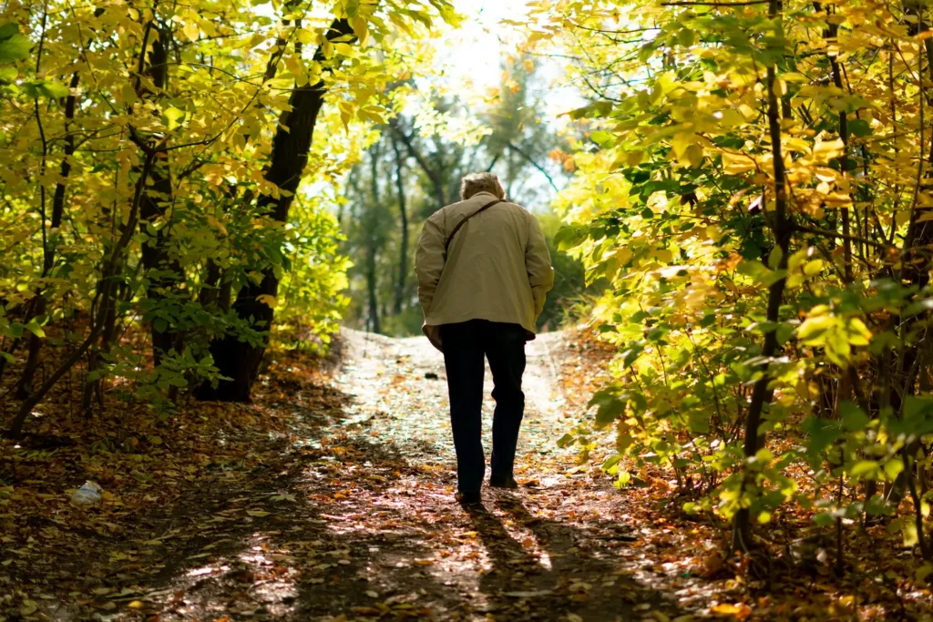 Persona mayor caminando al aire libre para mejorar la salud ósea